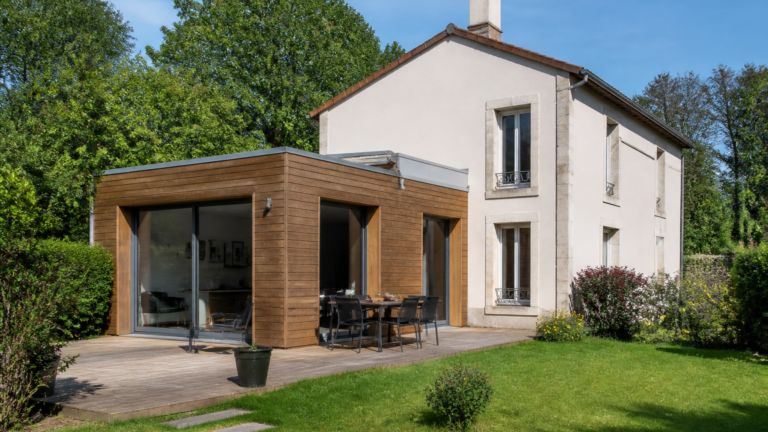 Extension moderne en bois et verre sur une maison individuelle française dans un jardin
