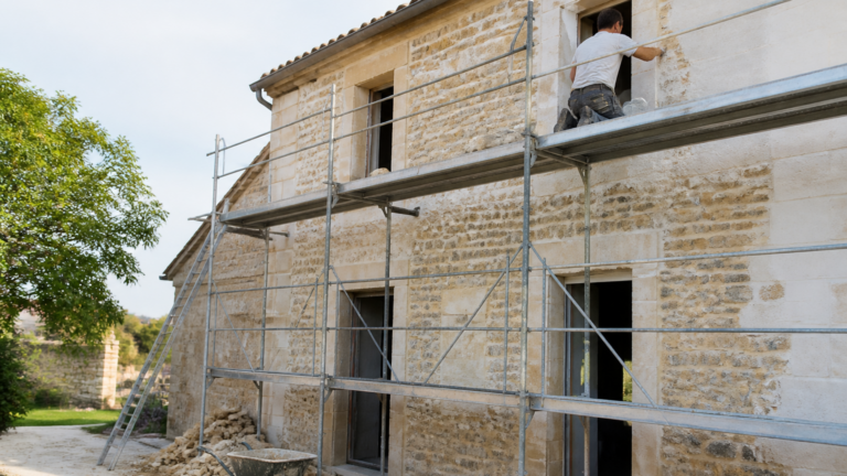 Artisan travaillant sur la rénovation d'une maison ancienne avec échafaudage