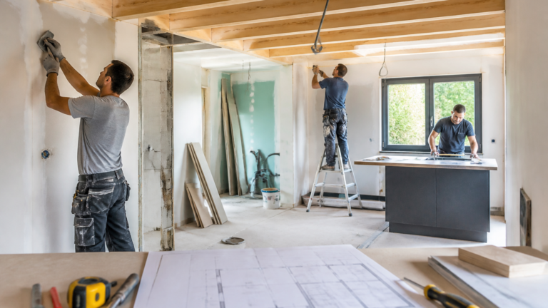 Maison en rénovation intérieure avec artisans au travail et plans